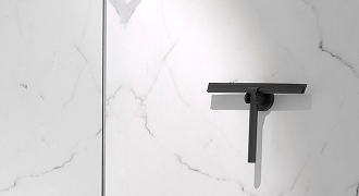 Zwarte X²O douchewisser op een marmeren wand aan een houder.